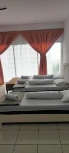 a group of four beds in a room with a window at Camelia Youth City Nilai Studio residence 5pax in Nilai