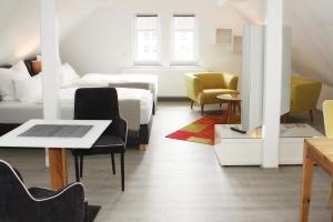 a living room with a bed and a table and chairs at Apartments im Chateau d'Esprit in Höhr-Grenzhausen