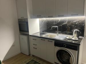 eine Küche mit einer Waschmaschine und einem Waschbecken in der Unterkunft Deluxe apartment bllok in Tirana