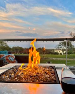 eine Feuerstelle auf einem Tisch mit einem Glas Wein in der Unterkunft Casa del Golf in Alcaidesa