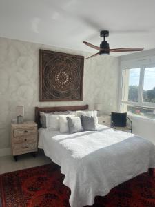 a bedroom with a large white bed with a ceiling fan at Casa del Golf in La Alcaidesa