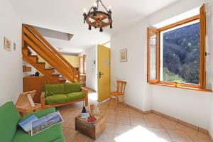 un soggiorno con divano verde e finestra di Casa Lara - Happy Rentals a Lugano