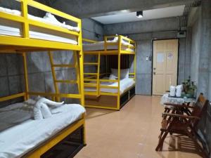 バンコクにあるOYO 560 Chang Hostel Suvarnabhumiの二段ベッド2台と廊下が備わる客室です。
