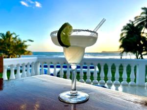 uma margarita com lima num copo sobre uma mesa em Emerald Luxe Suites em Big Corn Island