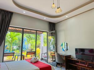 1 dormitorio con 1 cama, TV y ventana en Fla Village en Phu Quoc
