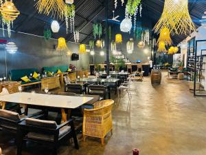 a dining room with tables and chairs and chandeliers at The Shed Venue & Boutique Hotel in Lilongwe