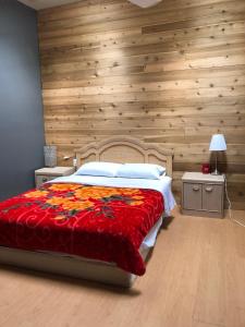 1 dormitorio con 1 cama grande y pared de madera en Dalat Second Vacation Home, en Lantzville