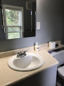 lavabo blanco en el baño con espejo en Dalat Second Vacation Home, en Lantzville