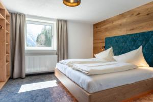 a bedroom with a large bed with a wooden headboard at Maurig Appartements in Elbigenalp