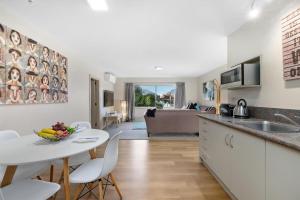 a kitchen and living room with a table and chairs at Distinctive Stylish and Spacious Family Home in Queenstown