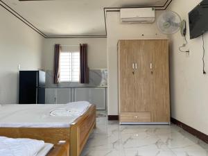 a room with two beds and a cabinet in it at Khách sạn An Thịnh in My Luong