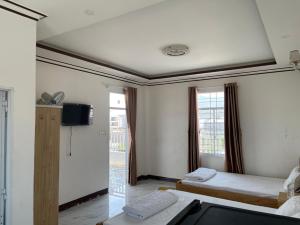 a hotel room with two beds and a television at Khách sạn An Thịnh in My Luong