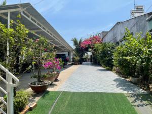 a walkway with potted plants and flowers at Khách sạn An Thịnh in My Luong