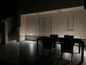 a dining room with a black table and chairs at Villa EnVi in Novalja