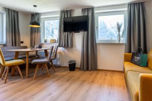 a living room with a table and a couch at Maurig Appartements in Elbigenalp