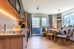 cocina con mesa y sillas y comedor en Maurig Appartements, en Elbigenalp