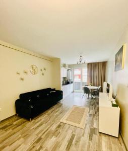 a living room with a black couch and a table at Home Sweet Home in Braşov +2 photos