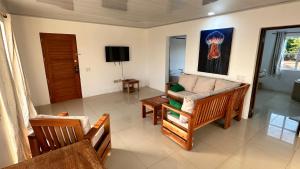 un soggiorno con divano e TV di Emerald Luxe Suites a Big Corn Island