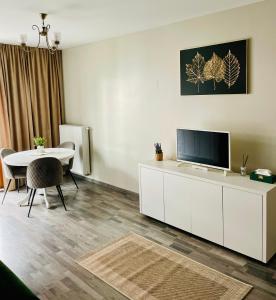 a living room with a tv and a dining table at Home Sweet Home in Braşov