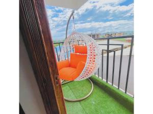 un fauteuil orange suspendu à un balcon dans l'établissement CH Two Bedroom Apartment Kisii, à Kisii