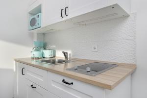 a kitchen counter with a sink and a microwave at Seaside Apartment with Balcony in Pobierowo - Close to Beach by Renters in Pobierowo