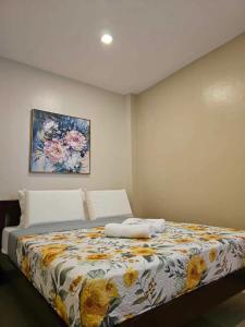 1 dormitorio con 1 cama con manta de flores en PrimeRose Residences, en Lapu Lapu City