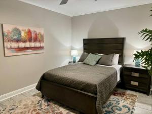 a bedroom with a bed and a painting on the wall at A Gem on the Strand in Galveston