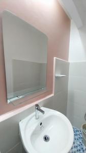 ein Badezimmer mit einem weißen Waschbecken und einem Spiegel in der Unterkunft PrimeRose Residences in Lapu Lapu City