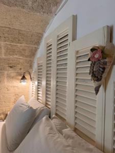 1 dormitorio con 1 cama y una pared con persianas en B&B Casa Fiore, en Polignano a Mare
