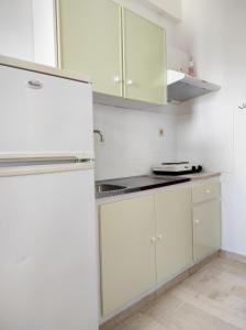 a kitchen with white cabinets and a refrigerator at Νέος Πύργος Δίκλινο in Néos Pírgos