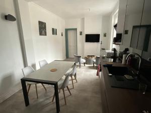 eine Küche und ein Wohnzimmer mit einem Tisch und Stühlen in der Unterkunft Ancienne maison de maitre in Douai