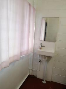 La salle de bains est pourvue d'un lavabo et d'un miroir. dans l'établissement Minjerribah Island Accommodation Straddie, à Dunwich
