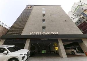 um carro branco estacionado em frente a um hotel carillion em Carlton Hotel Bupyeong em Incheon