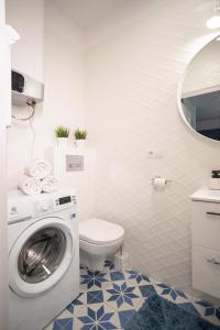 a bathroom with a washing machine and a toilet at Międzymorze 1024 in Jurata