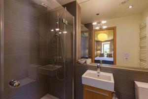 a bathroom with a shower and a sink and a mirror at Chalet Plein Centre - Savoyard Moderne - Happy Rentals in Chamonix