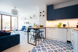 a kitchen with black cabinets and a blue couch at Międzymorze 1024 in Jurata