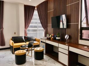 a living room with a tv and a couch and a table at Anh Nguyet Da Nang Hotel in Danang