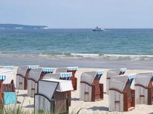 a row of chairs and tables on a beach at Residenz Margarete - Apt. 1.3 in Binz