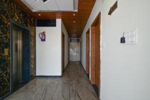 a hallway of a building with white walls and tile floors at FabHotel SS Blue in Indore