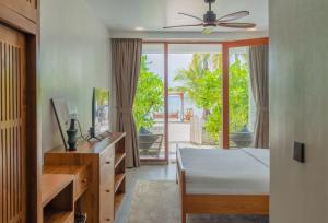 a bedroom with a bed and a desk and a window at Veli Vilaa Dhiffushi - Beachfront in Dhiffushi