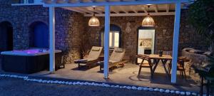 a patio with a table and chairs and a tub at BLUE SERENITY VIEW in Houlakia