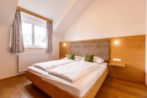 sypialnia z dużym łóżkiem i dużym oknem w obiekcie Almresort Gartnerkofel Nassfeld w mieście Sonnenalpe Nassfeld