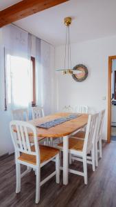 comedor con mesa de madera y sillas blancas en Ferienhaus Taeffner en Ebern