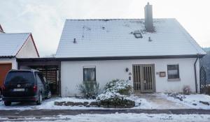 una casa blanca con una furgoneta estacionada frente a ella en Ferienhaus Taeffner en Ebern