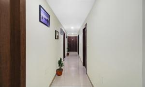 a hallway of a house with white walls and a plant at Hotel Park Central in Kolkata +24 photos