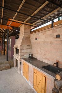 an outdoor kitchen with a stone fireplace in a building at Edits Home in Dsegh