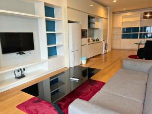 - un salon avec une télévision, un canapé et une table dans l'établissement Luxe Suites at Platinum KLCC, à Kuala Lumpur