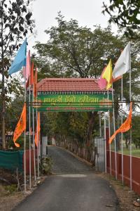 une porte avec des drapeaux sur le côté d'une route dans l'établissement Mahuli Agro Tourism, à Mansar
