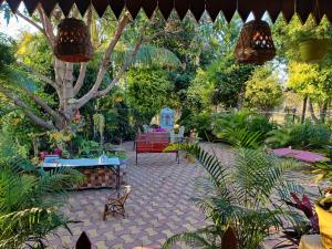 een tuin met een bank en bomen en planten bij Mahuli Agro Tourism in Mansar