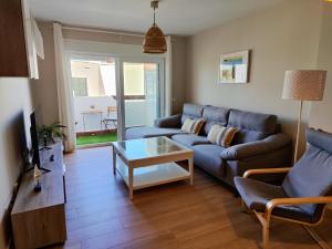 - un salon avec un canapé bleu et une table dans l'établissement La Marina Beach 3 bedrooms Sun & Golf, à Torre de Benagalbón